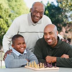 Single dad with his son and father playing chess