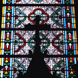 Cross in front of church stained glass window