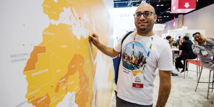 Man stands in front of world map at World Federation of Hemophilia World Congress  