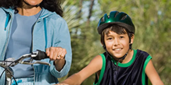 Mother and son riding with helmets. 