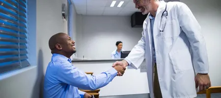 Male doctor shaking hands with male patient