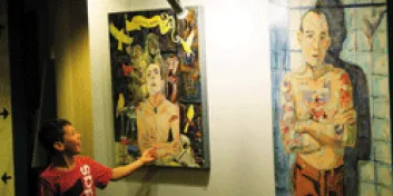 Boy admiring paintings hanging on wall